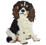 Embroidered patch depicting a Cavalier King Charles Spaniel in a tricolor coat (black, tan, and white), sitting and looking forward.