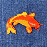Orange fish patch on blue denim fabric