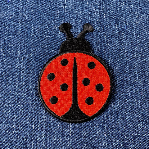 Red ladybug patch on a denim background