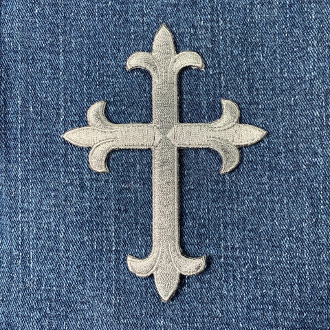 Decorative gray cross on a blue denim background
