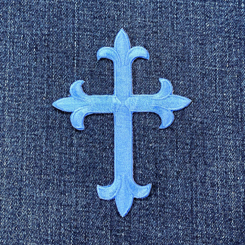 Decorative blue cross patch on a denim background