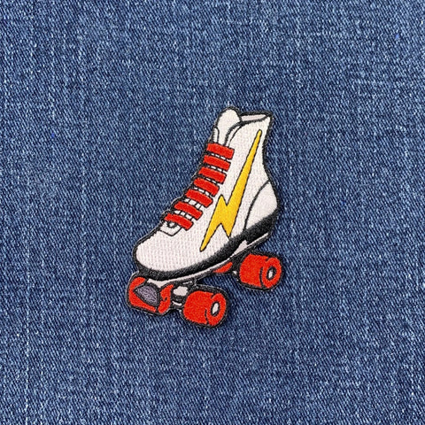 Roller skate patch with red laces and yellow lightning bolt on denim fabric
