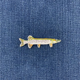 A realistic fish-shaped patch featuring a detailed pattern of green, brown, and gray scales, isolated on a denim background.