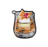 An embroidered patch of a whiskey old fashioned cocktail, on a white background.