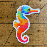Colorful seahorse sticker on a wooden surface