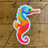 A colorful sticker depicting a seahorse with a geometric pattern of colors.