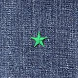 Mini green star patch on blue denim fabric