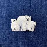 Embroidered patch of a polar bear family on denim fabric