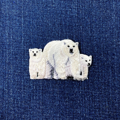 Embroidered patch depicting a polar bear with two cubs on a denim background