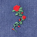 Embroidered red rose patch on denim fabric