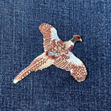 Embroidered pheasant patch on denim fabric