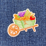 Embroidered patch of a wheelbarrow with vegetables on denim fabric