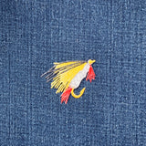 Colorful fly fishing lure patch on denim fabric
