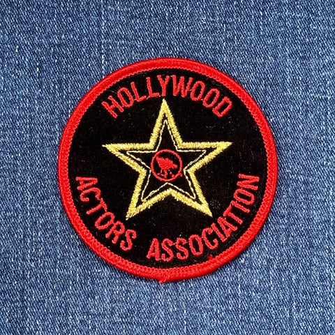 A collectible patch from Hollywood Actors Association featuring a stylized Hollywood logo with red, black, and gold colors on a denim background