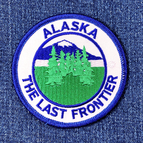 Alaska patch with trees and mountains on a blue denim background