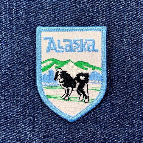 Embroidered patch with 'Alaska' text and dog illustration on denim fabric