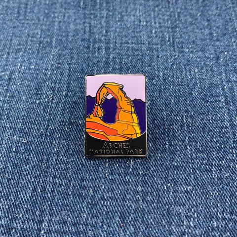 Pin with Arches National Park design on a denim background