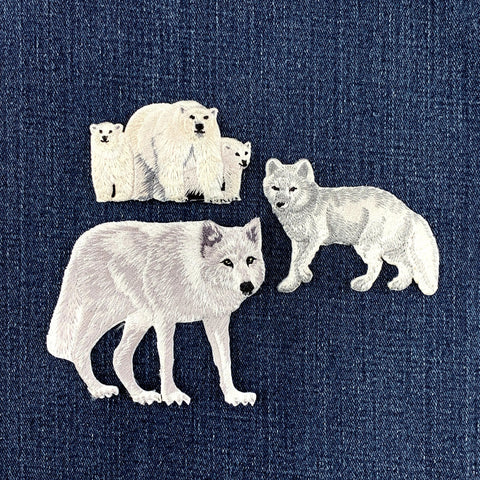 Embroidered patches of polar bears, a fox and a wolf on denim fabric