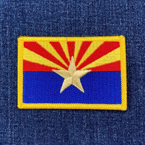 Embroidered patch of the Arizona state flag on denim fabric.