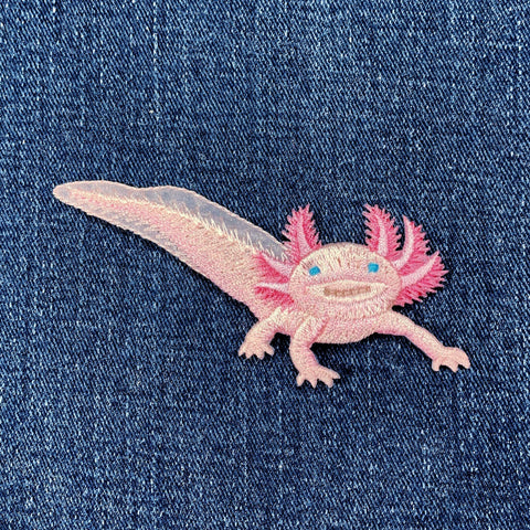 Embroidered axolotl patch on denim fabric