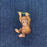Embroidered monkey patch on denim fabric