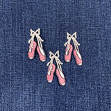 Embroidered pink ballet shoe patches on a denim background