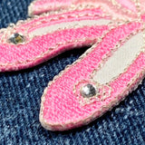 Close-up of pink ballet slippers on a denim background