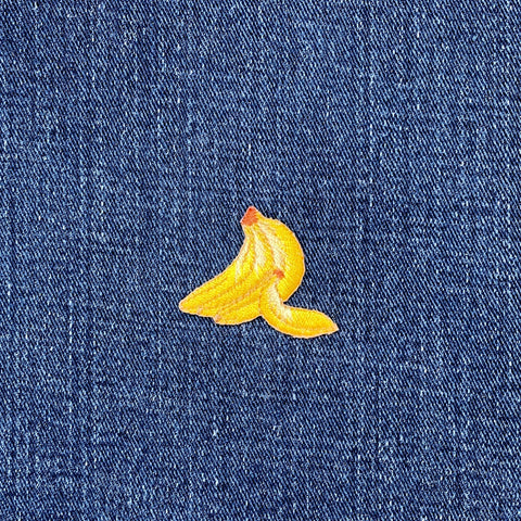 Embroidered yellow banana patch on blue denim fabric