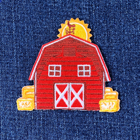 Red barn patch with a yellow sun on a blue denim background