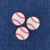 Three baseball-shaped patches with red stitching on a denim background