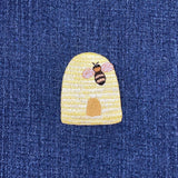 Embroidered bee and beehive patch on denim fabric