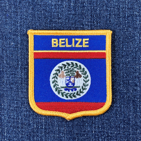 Embroidered patch with 'BELIZE' text on a blue background with red and yellow border, on a denim fabric.