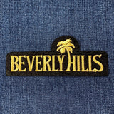 Embroidered 'Beverly Hills' patch with palm tree on blue denim fabric