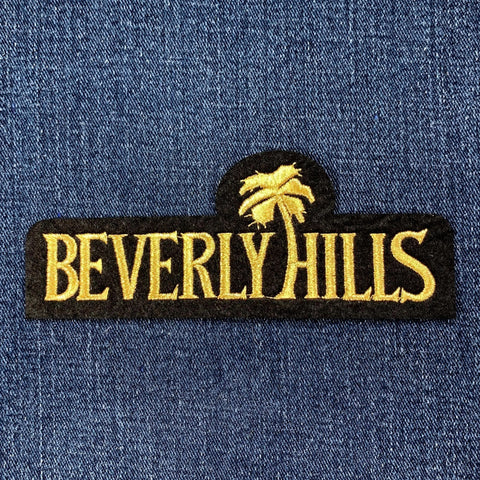 Embroidered 'Beverly Hills' patch with palm tree on blue denim fabric