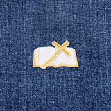 Embroidered patch of a bible and cross on denim fabric