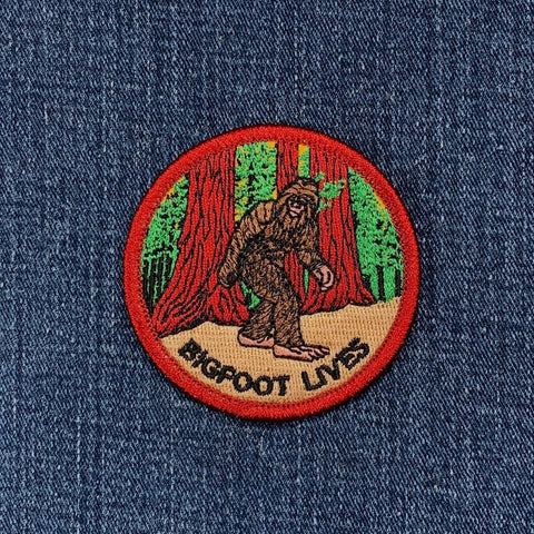 Embroidered patch with a Sasquatch design and 'Bigfoot Lives' text on denim fabric.