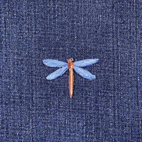Embroidered dragonfly patch on denim fabric