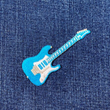 Blue electric guitar patch on denim fabric
