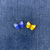blue and yellow butterfly patches on a denim background