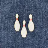 Three embroidered bowling pins on denim fabric