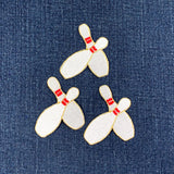 Three bowling pin patches on a denim background
