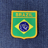 Embroidered patch of the Brazilian flag on a blue denim background