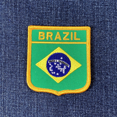 Embroidered patch of the Brazilian flag on a blue denim background
