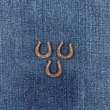 three brown horseshoe patches on a denim background
