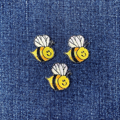 Three bee-shaped patches on a denim background