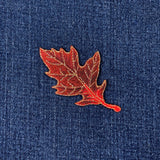 burgundy leaf patch on blue denim fabric