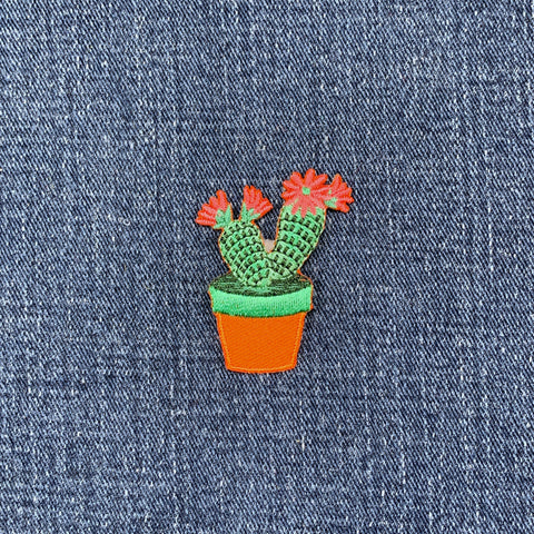 Cactus plant patch with pink flowers on denim fabric