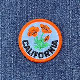 Embroidered patch with California poppies on denim fabric