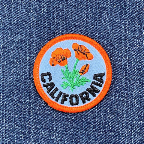 Embroidered patch with California poppies on denim fabric