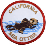 A circular embroidered patch featuring a California sea otter swimming in blue water, with 'CALIFORNIA' at the top and 'SEA OTTER' at the bottom in tan lettering on a white background with a red border.